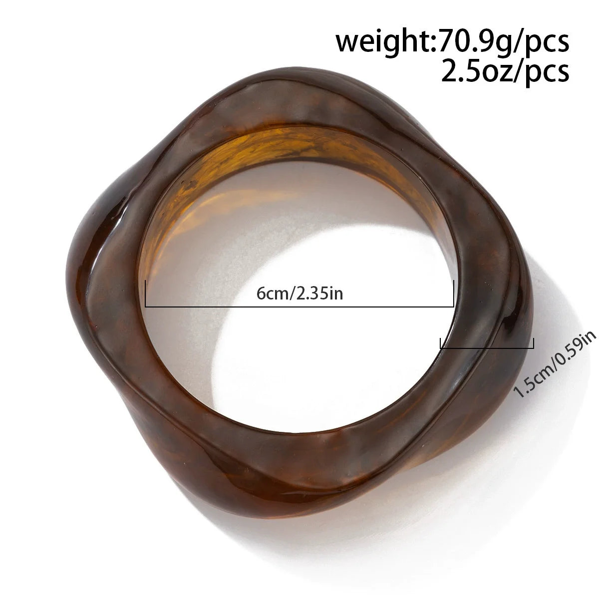 Vue rapprochée d'un bracelet manchette en acrylique ambre foncé, au design arrondi et lisse.