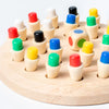 A wooden memory chess game for kids featuring various colored pegs and pieces arranged on a light wooden board.