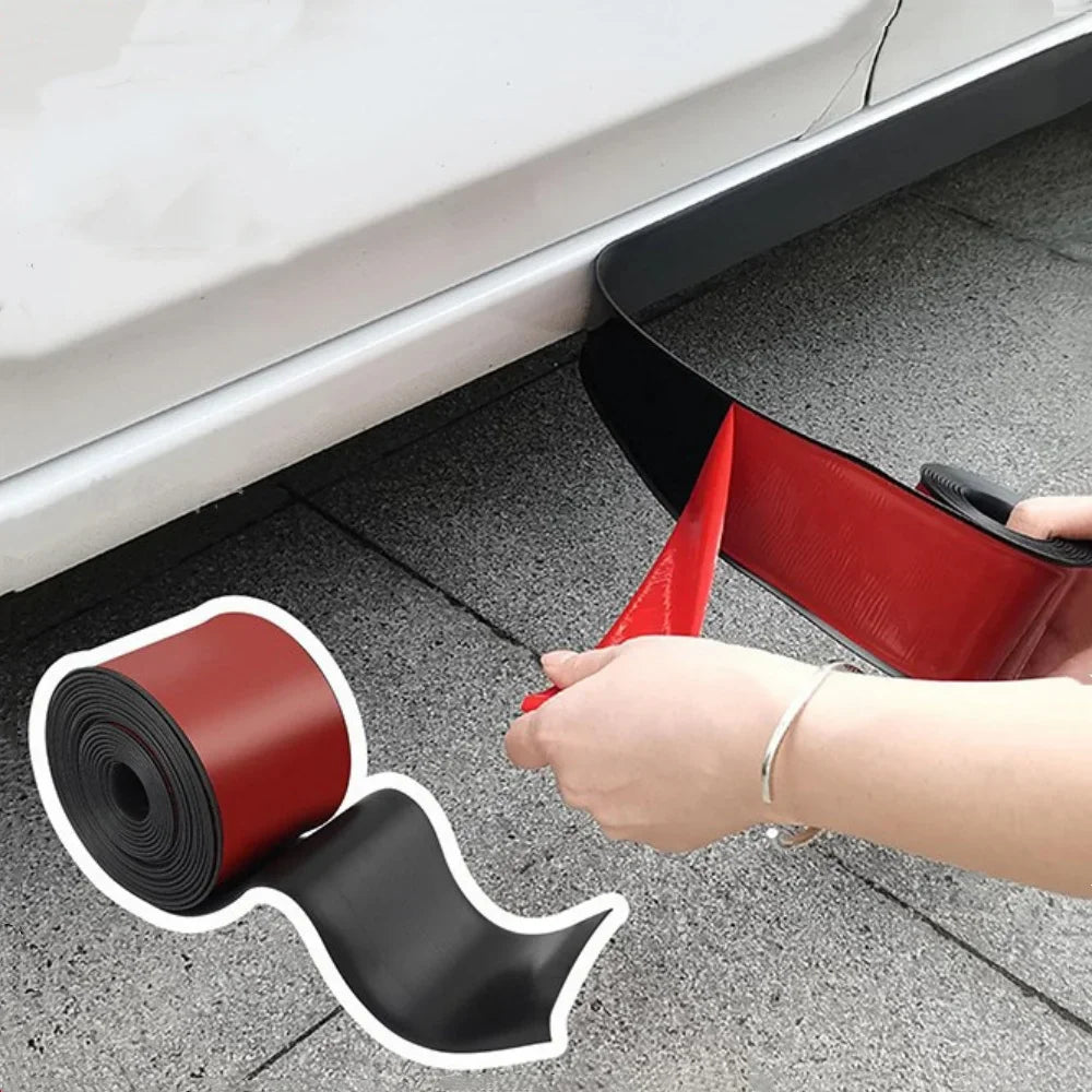 A hand is applying a self-adhesive car door edge protector strip, which is red and black, to the side of a white car.