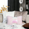 A pink sequin fur cushion cover with silver and gold accents resting on a white fluffy surface.