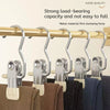 Stainless steel clothespins with hooks used to hang laundry on a wooden bar.