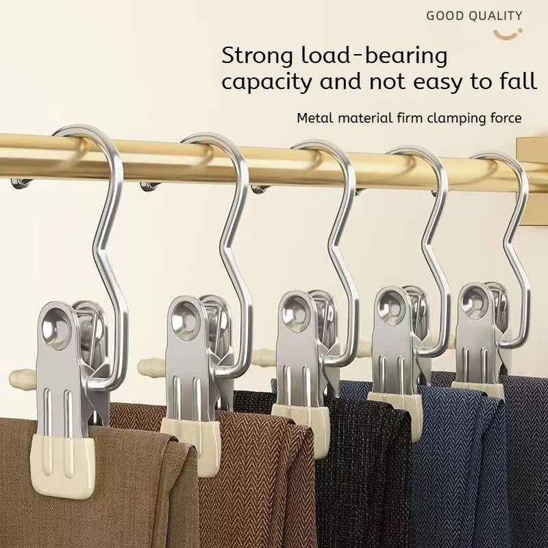 Stainless steel clothespins with hooks used to hang laundry on a wooden bar.
