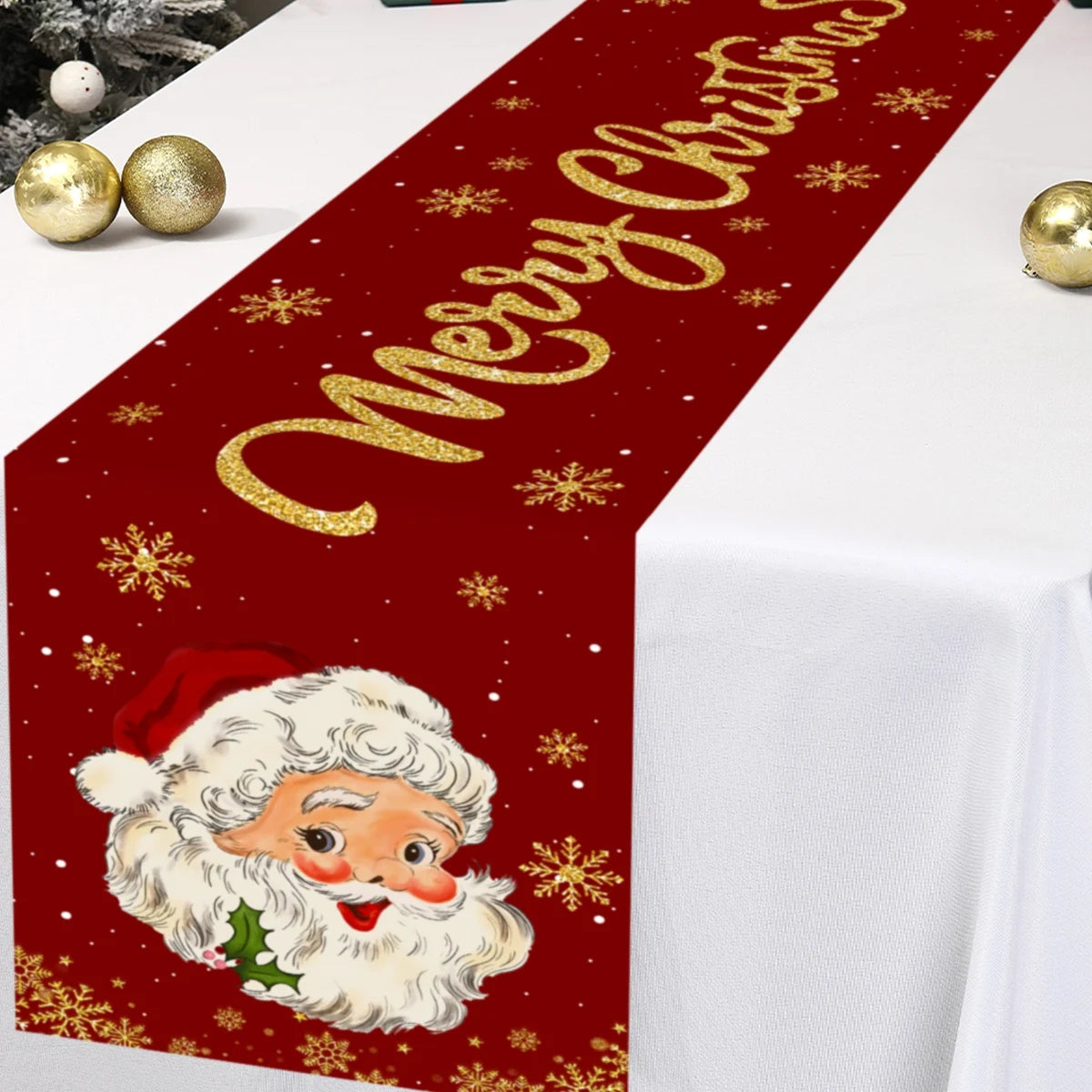 A festive red table runner featuring gold sparkling text and Christmas snowflakes with a Santa Claus illustration.