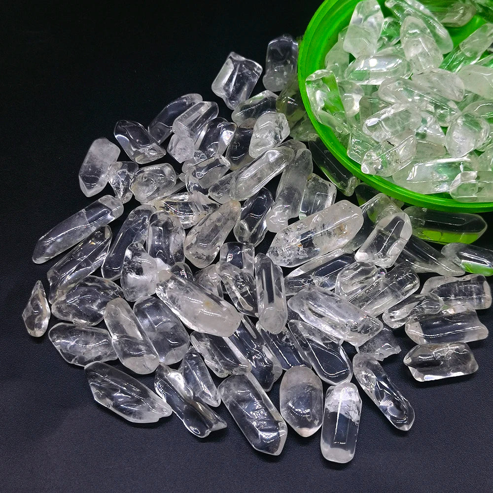 Clear crystal stone chips and tumbled stones in a green bowl on a dark surface