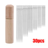A set of 30 self-threading sewing needles with a wooden storage cylinder.