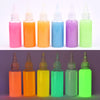 A row of 8 glass bottles filled with various brightly colored liquid craft materials for a DIY kit.