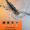 Industrial endoscope probe being used to inspect a pipe, showing water splashing around the tip.