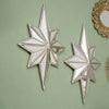 A pair of silver octagonal star resin wall mirrors with gold trim displayed against a muted green background.