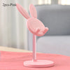 Pink rabbit mobile phone and tablet stand with two pieces shown on a pink surface