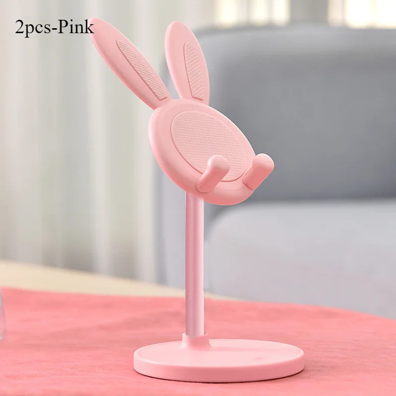 Pink rabbit mobile phone and tablet stand with two pieces shown on a pink surface