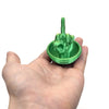 A hand holds a green plastic egg shaped like a middle finger for desk decor.