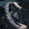 A hand grips a crystal rhinestone steering wheel cover on a car's steering wheel.