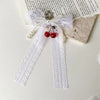 White pearl bow keychain with a heart charm tied on a piece of parchment paper