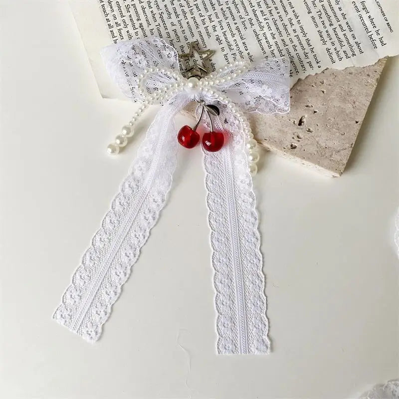 White pearl bow keychain with a heart charm tied on a piece of parchment paper