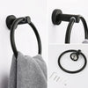 Matte black bathroom hardware set including a toilet paper holder, towel ring, and hooks.