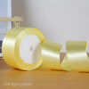 A roll of light yellow satin ribbon used for gift wrapping or DIY crafts.