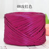 A magenta metallic flat ribbon yarn skein rolled into a cylinder.
