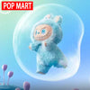 A fluffy blue Labubu plush doll with large eyes is shown inside a clear bubble.