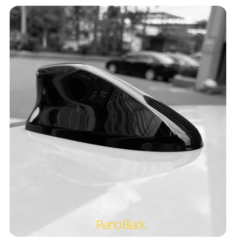 Piano Black sleek shark fin antenna cover for a vehicle, shown in profile.