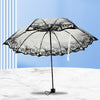A black umbrella with a transparent canopy featuring a floral design is shown against a light blue background.