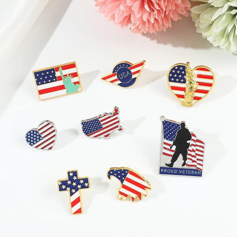 A collection of enamel pins featuring American flag designs, including stars, stripes, and patriotic symbols.