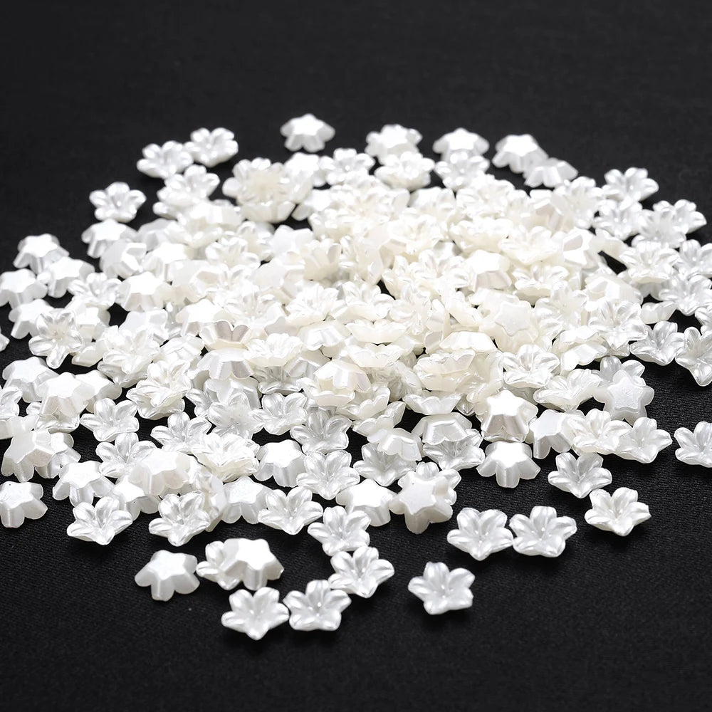 A pile of 100 clear white acrylic pearl spacer beads for jewelry making.