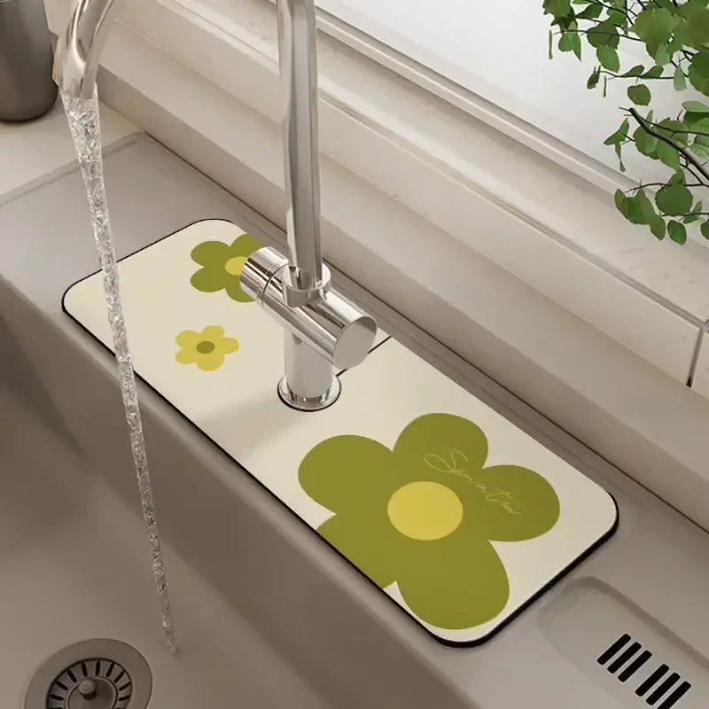 A yellow floral diatomaceous earth faucet mat is placed on a bathroom sink with a chrome faucet.