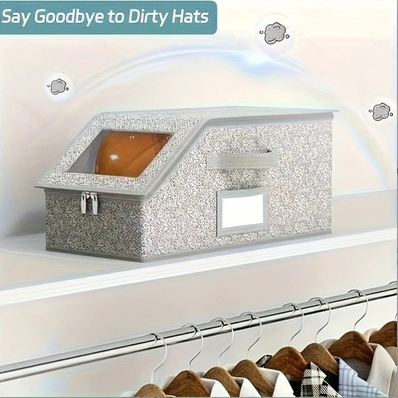 A gray fabric storage box with a slanted opening and zipper is displayed on a shelf, used for storing hats and accessories.