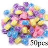 A pile of colorful water-soluble laundry fragrance beads in various shades of purple, blue, and yellow.