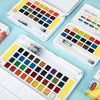An open watercolor paint set featuring various colors and water brush pens arranged in compartments.
