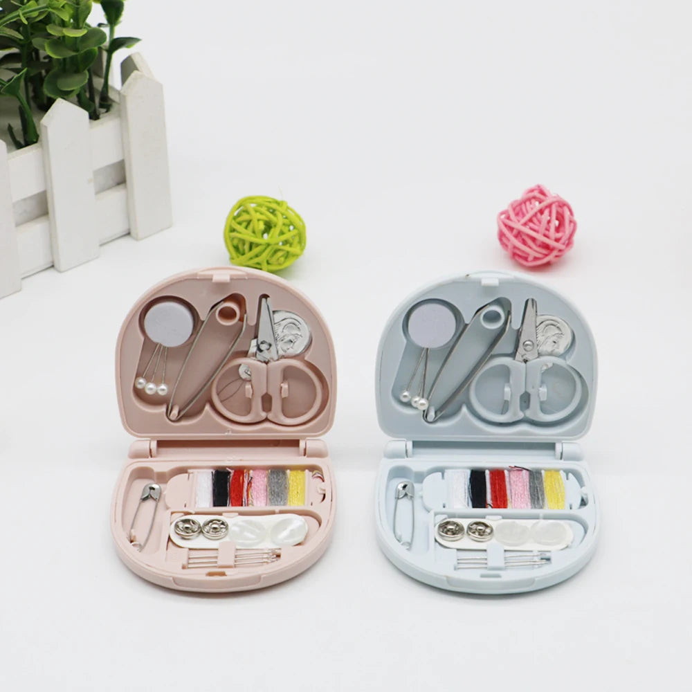 A portable mini sewing kit with scissors, needles, and thread is shown open next to a ball of pink yarn.