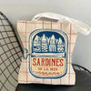 A canvas tote bag featuring a blue print of sardines on a red and white checkered background.