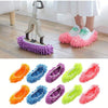 Five pairs of colorful reusable microfiber mop slippers for dusting and cleaning shown on a wooden floor.