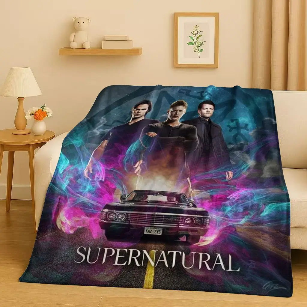 A dark purple and blue blanket featuring characters and a car from the Supernatural TV show.
