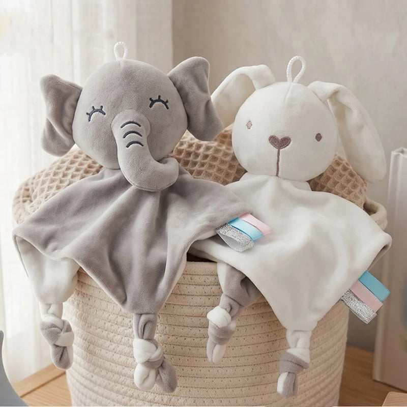 A gray elephant plush toy with a comfort blanket and teether is resting on a woven basket.