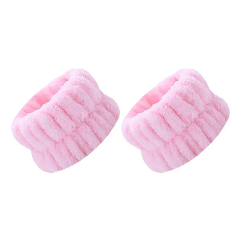 A pair of pink absorbent microfiber wrist washing bands or face-saving cuffs.