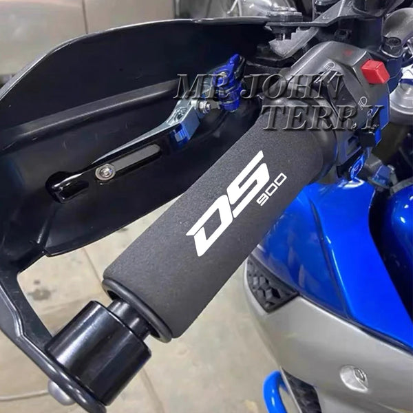 Close-up of a black DS 900 motorcycle handlebar grip cover installed on a blue motorcycle.