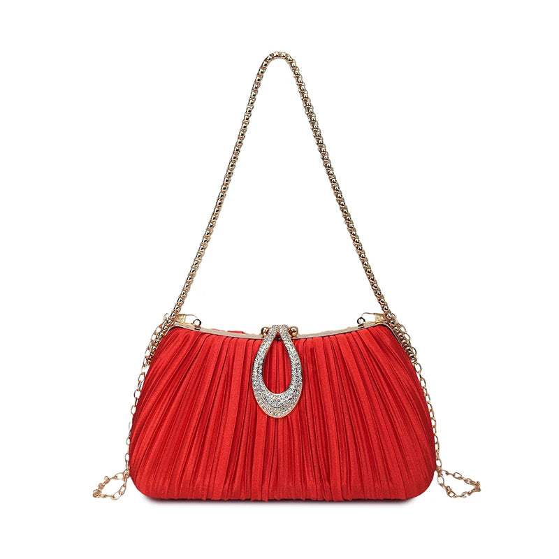 A vibrant red pleated evening clutch with a gold chain strap and a rhinestone closure.