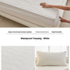 White waterproof mattress protector shown with a fitted cover and pillow, emphasizing its soft and clean features.