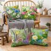 A collection of floral throw pillows featuring various wildflowers and greenery on a wooden chair and rustic table.