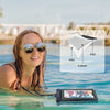 A woman wearing sunglasses is floating in water with a waterproof phone case visible nearby.