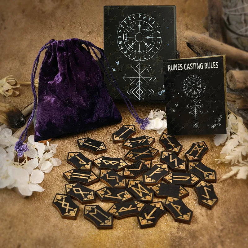 A set of wooden rune stones, a guide book, and a purple velvet bag are displayed on a rustic surface.