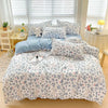 A light gray and white patterned bedding set featuring a duvet cover, fitted sheet, and pillows on a bed.