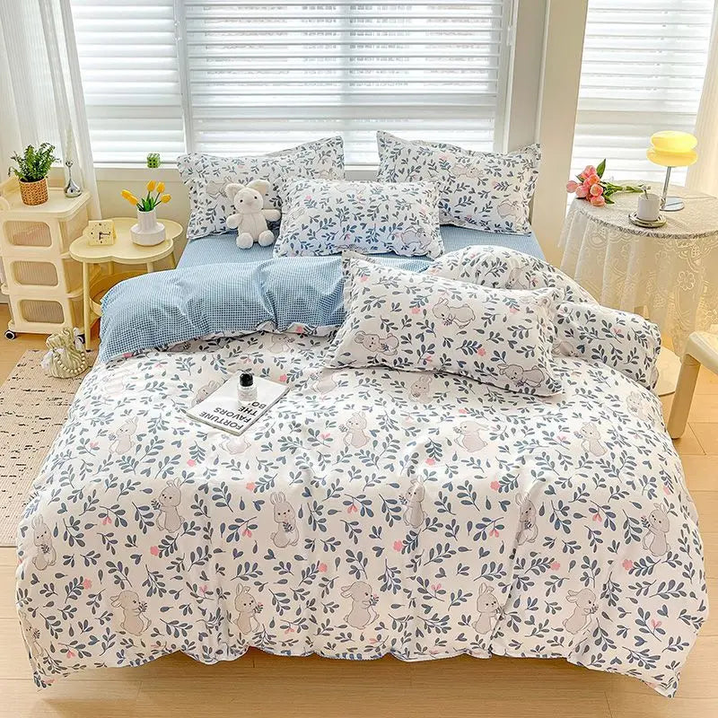 A light gray and white patterned bedding set featuring a duvet cover, fitted sheet, and pillows on a bed.