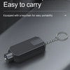 A black emergency car safety hammer with a keychain is shown resting on a dark gray surface.