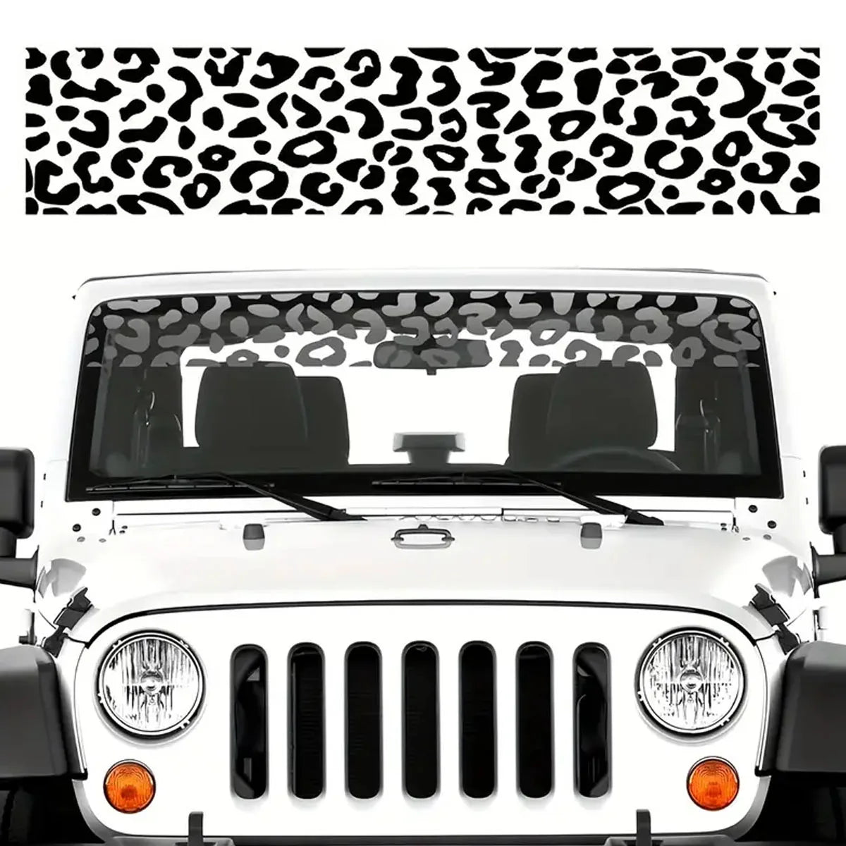 A white car's front windshield is covered with a black leopard print sunshade decal strip.