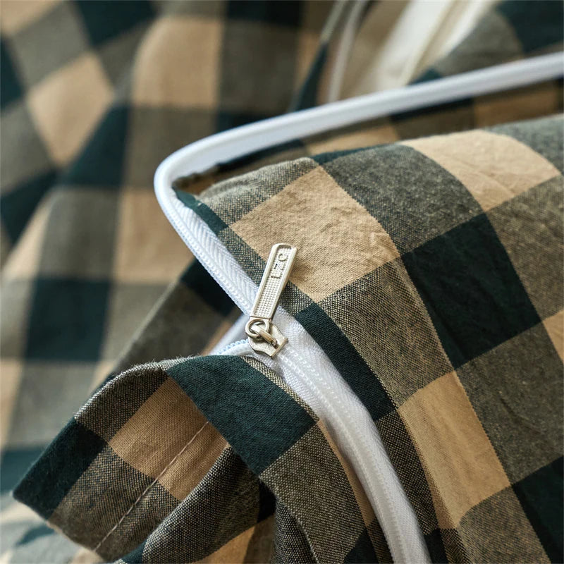 Close-up of a plaid duvet cover in earthy tones, showing the stitching and zipper detail.