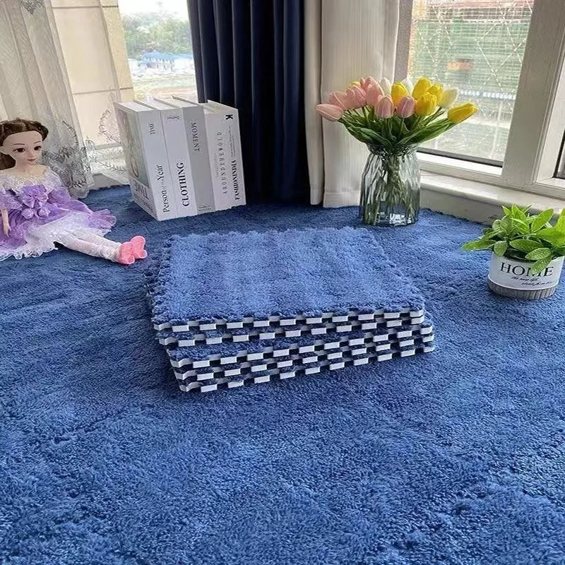 A blue plush interlocking floor mat with a striped edge is placed on a larger blue rug near a window with flowers.