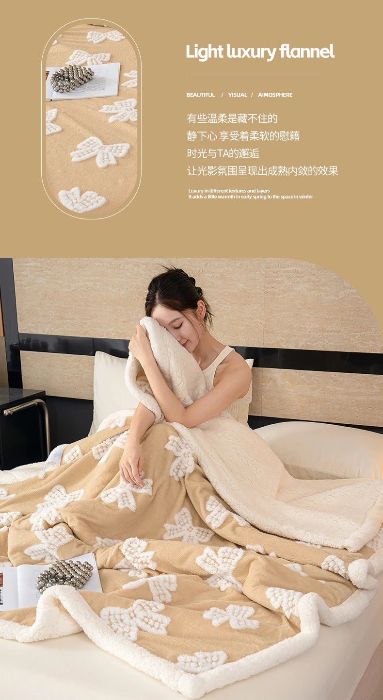 A beige plush jacquard throw blanket is draped over a bed, featuring white floral patterns.