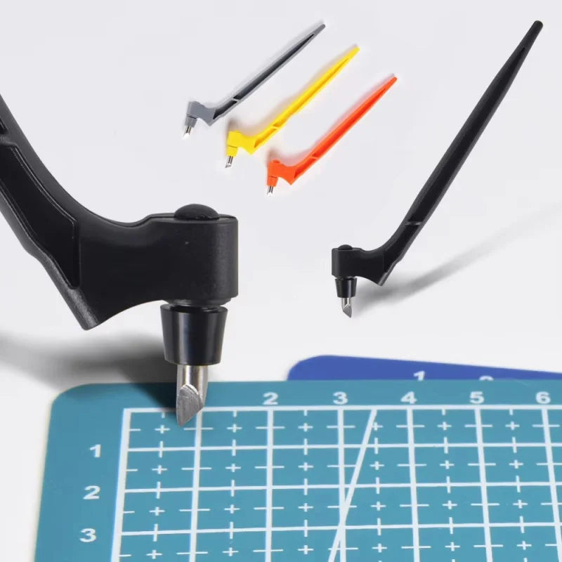 A black craft knife and several replacement blades in yellow, orange, and silver are shown above a grid ruler.
